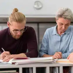 personas adultas realizando apuntes examen
